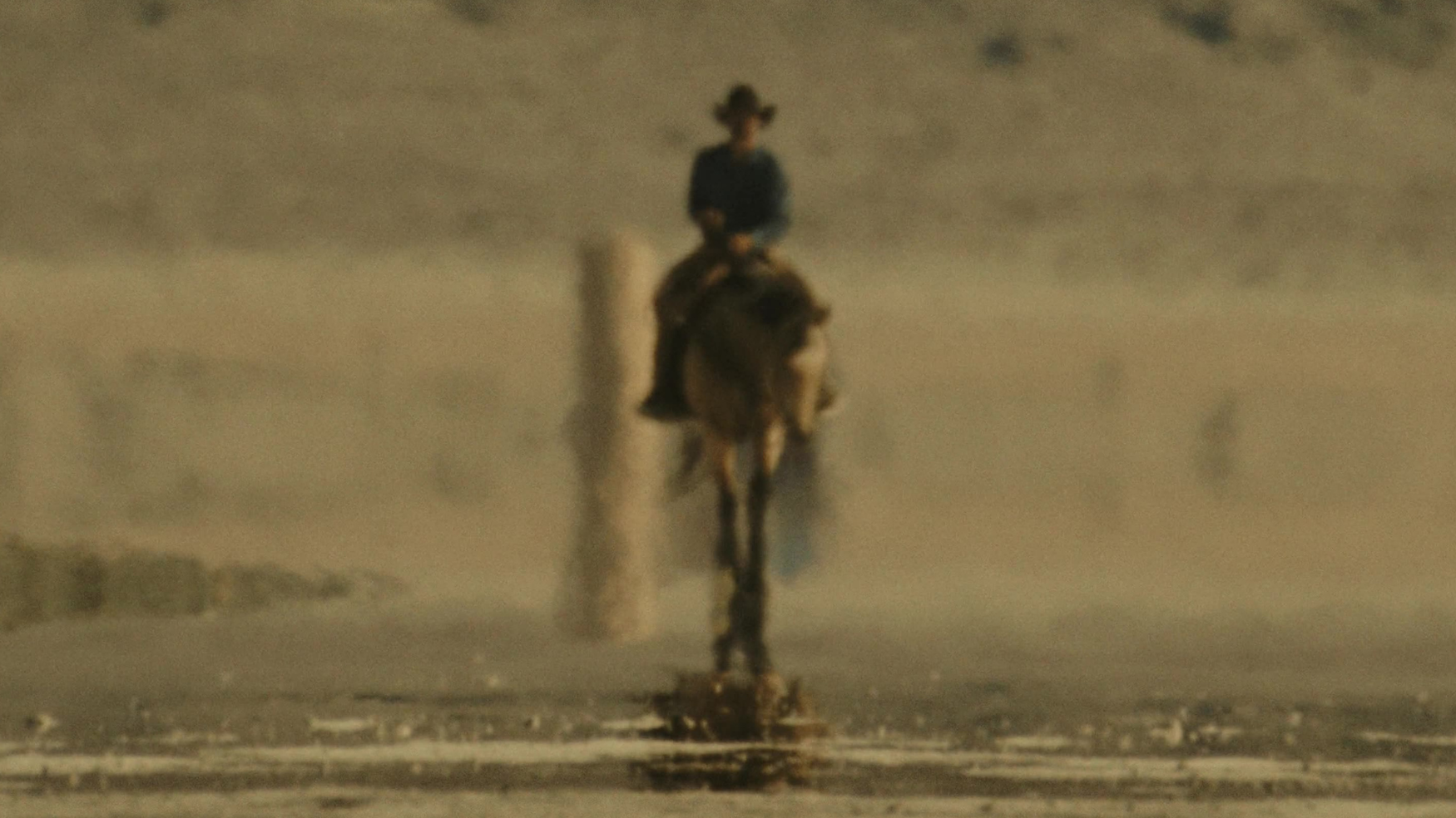A lone cowboy walks across a shimmering desert salt flat in the Porsche Mirage automotive spot