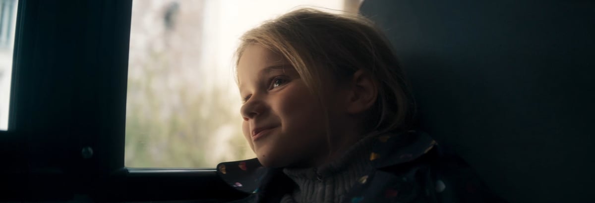  A young and beautiful child looking out of the school bus window