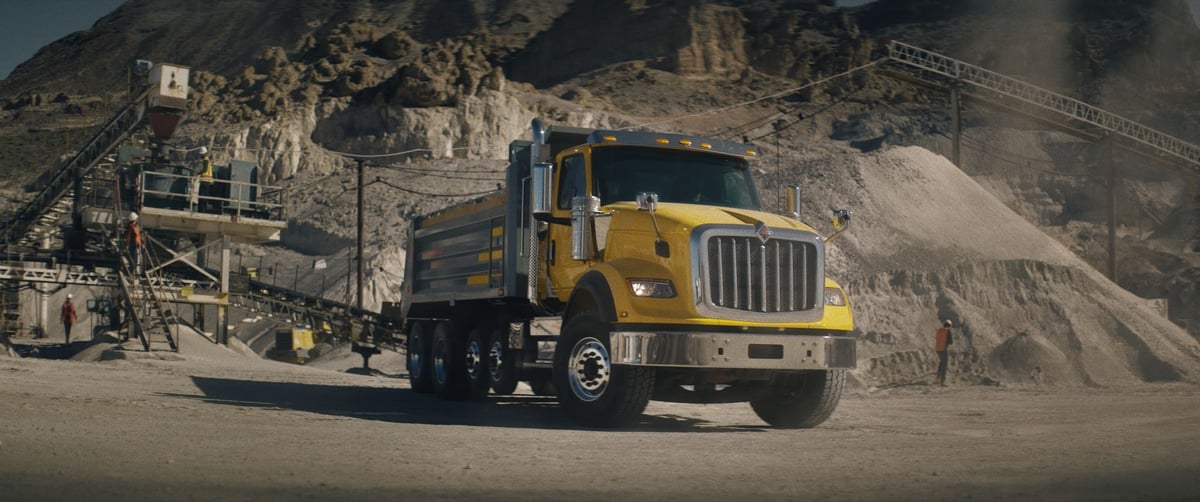 A stunning large yellow truck set against a sandy landscape.