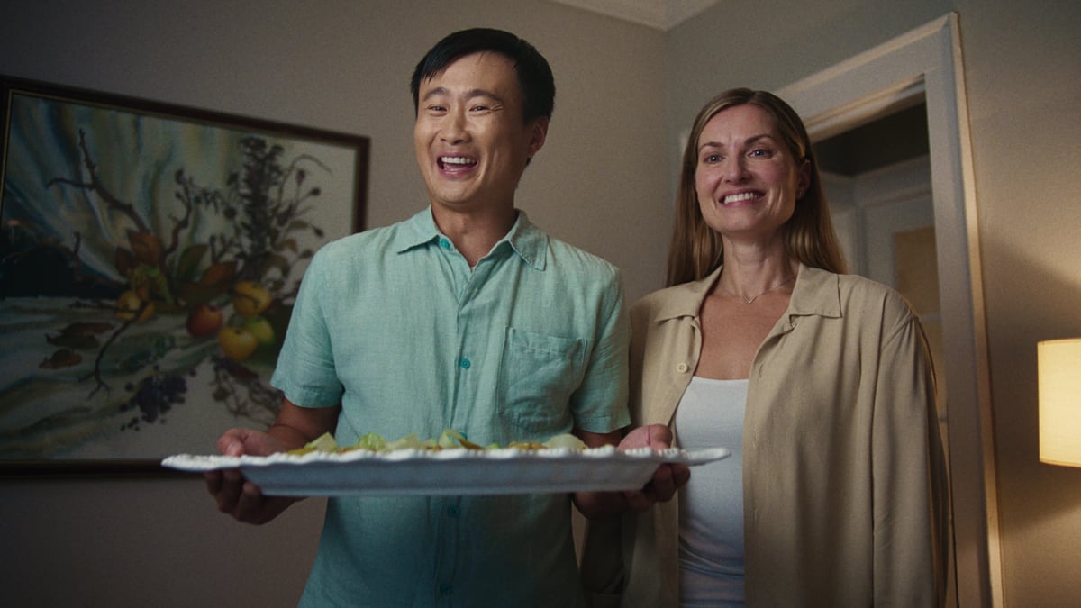 The couple happily hands over the platter of food.