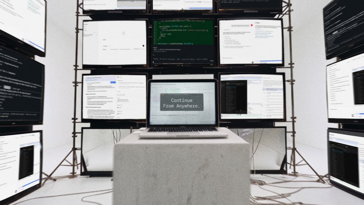 Camera dollies back to reveal the laptop centered on a concrete plinth inside a cathedral of monitors, the screen landing the line "Continue From Anywhere."
