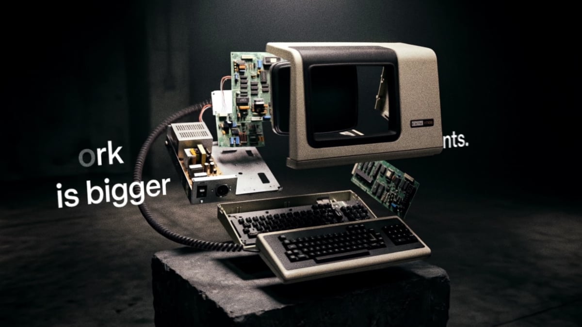 The terminal violently explodes outward in a frozen burst — CRT, boards, PSU, and keyboard suspended mid-detonation as residual type fragments drift through frame.