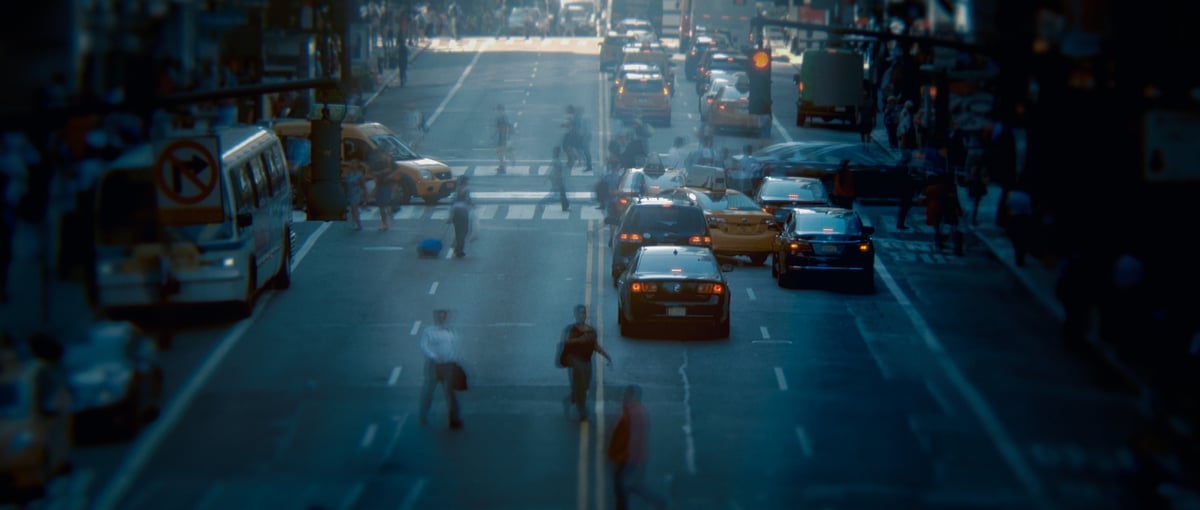  A picturesque scene of a lively street adorned with cars and people.