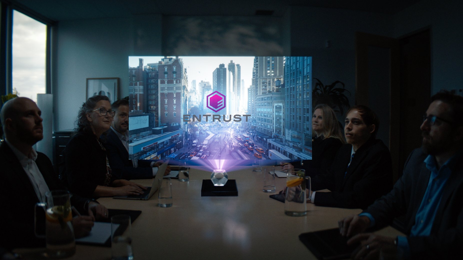 The team gathers around a desk during a meeting, focusing their attention on a holographic presentation.
