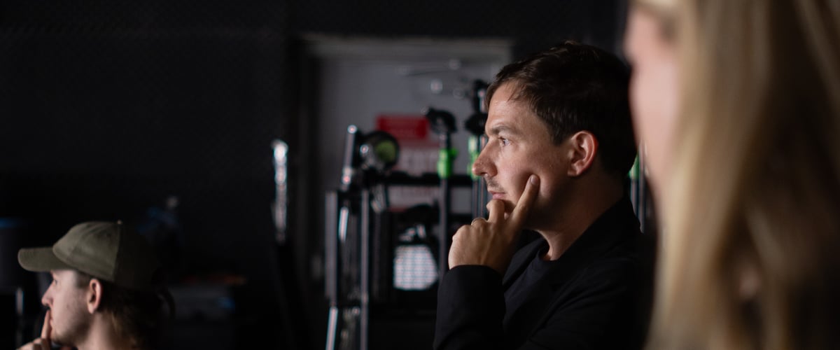 A member of the production crew is captured staring at the scene, hand on chin, deep in thought.
