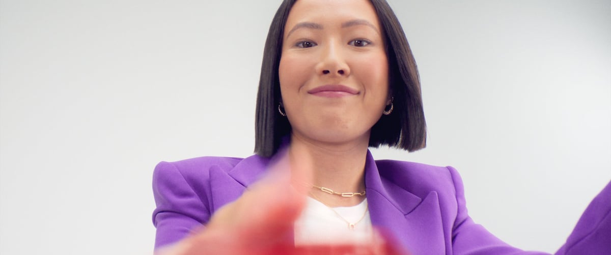 The woman smiles with joy as the inserted card is released from the ATM machine.