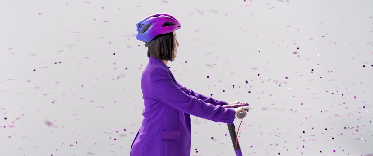 A side view of the woman on a scooter, getting ready to depart.