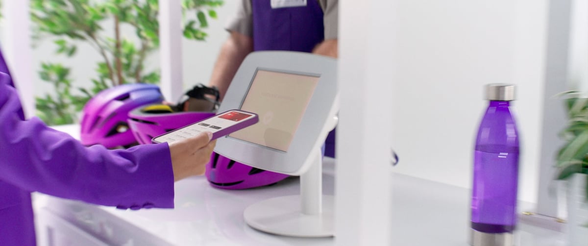 The woman is making a mobile transaction to the scanner.
