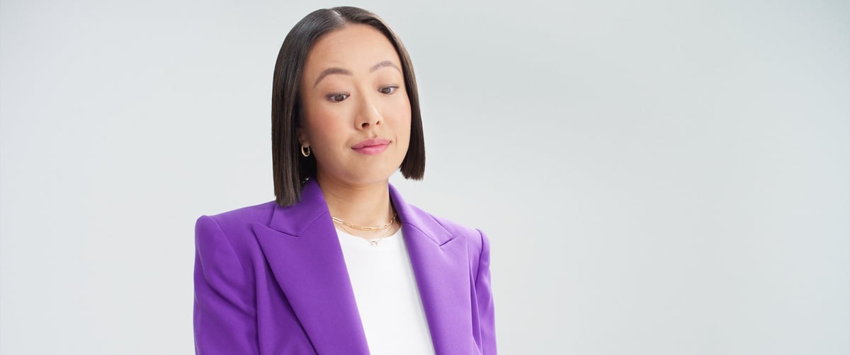 A confident woman looks down at her mobile phone, her expression reflecting assurance.