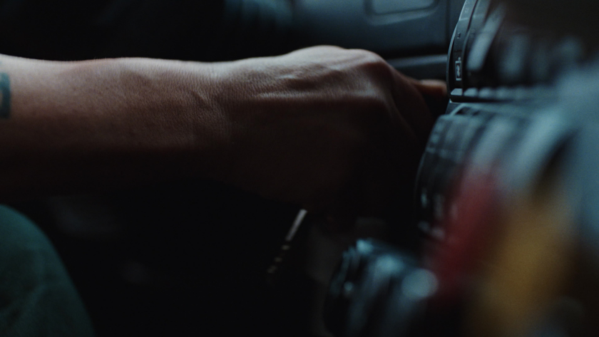 A close-up of a driver’s hand turning the ignition captures the tactile rhythm of life on the road.