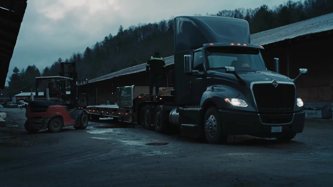 International Trucks fleet vehicles are staged at a misty mountain service facility, demonstrating commercial vehicle reliability and professional fleet management capabilities.