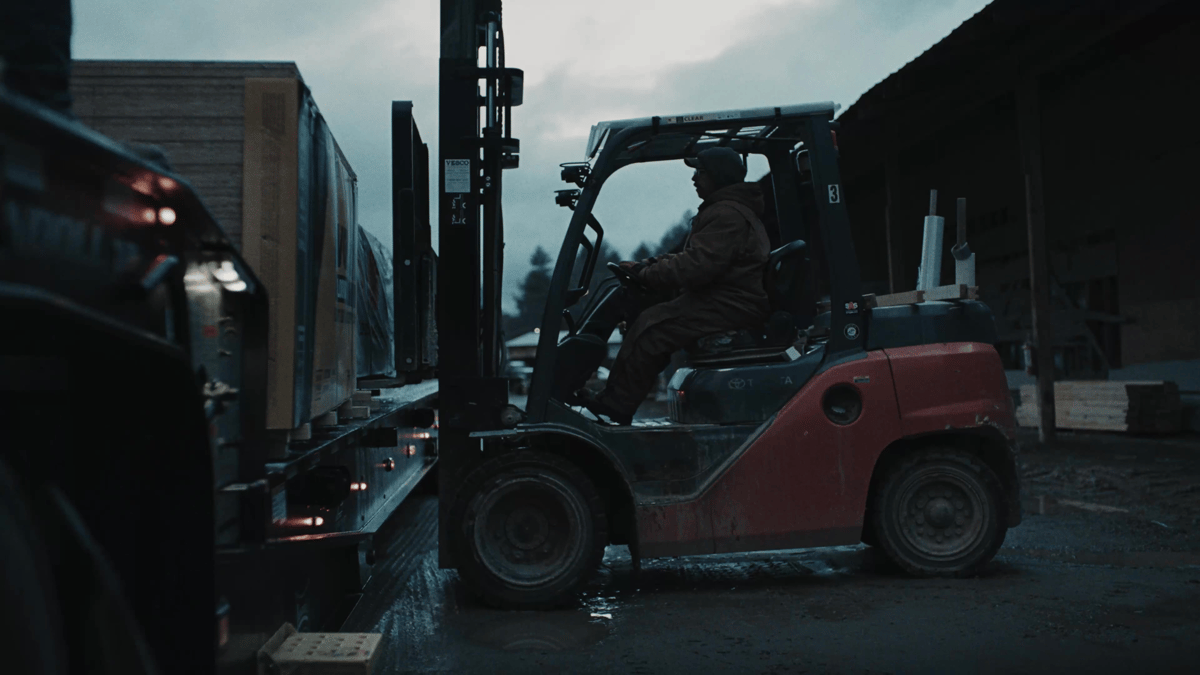 A forklift loads donated materials onto the flatbed, highlighting the hands-on labor behind the supply effort.