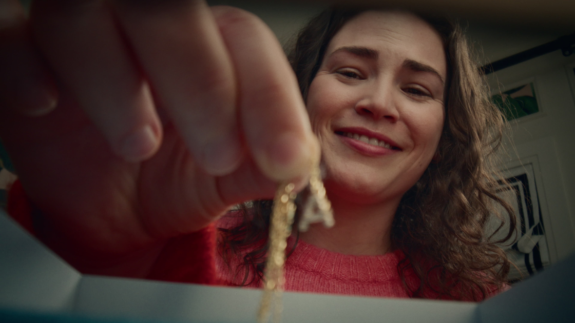 A daughter picking up a stunning piece of jewelry from a Jewlr box.