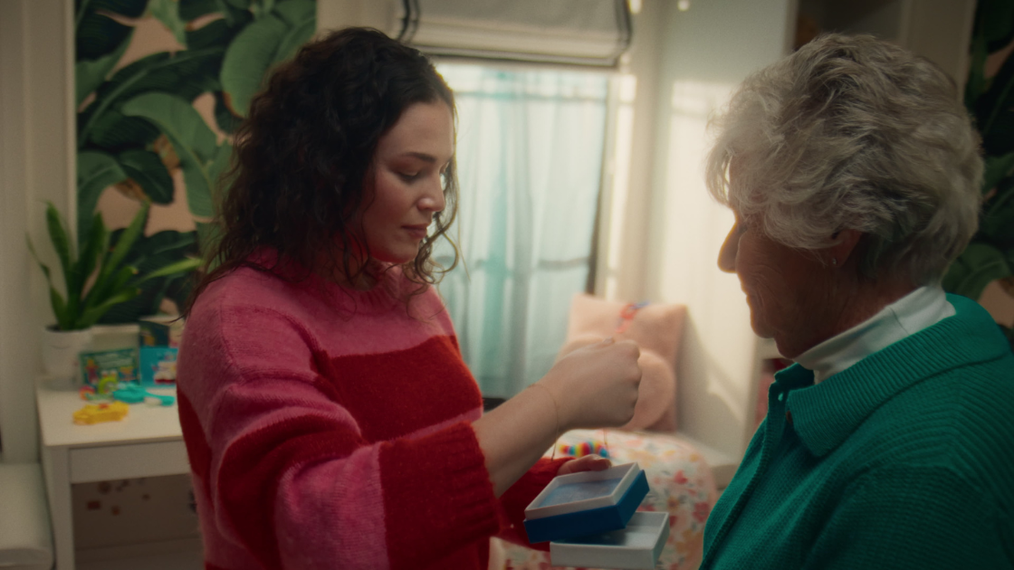 A daughter holding a gift from her grandmother, looking genuinely happy as she expresses her gratitude.