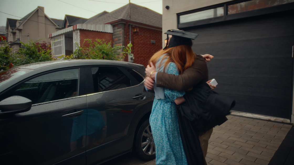 A graduating daughter hugging her father after receiving her gift.