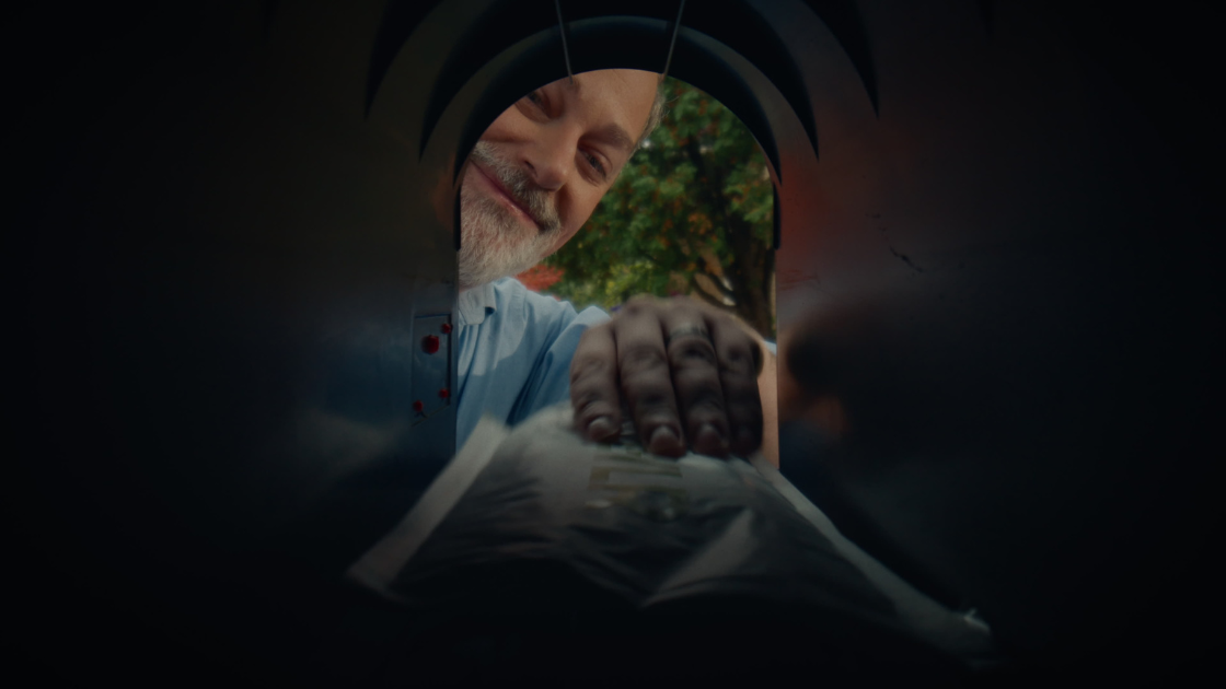 A bearded father retrieving a Jewlr package from his mailbox.