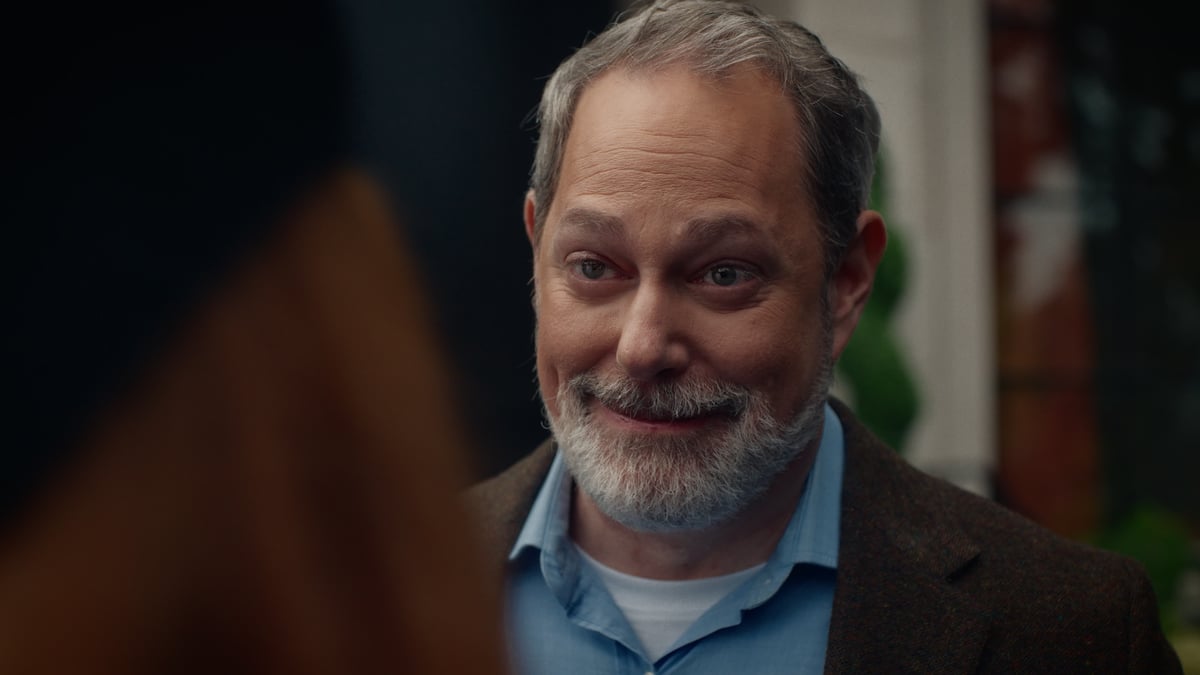 A bearded father looking emotional as his daughter appreciates his gift.