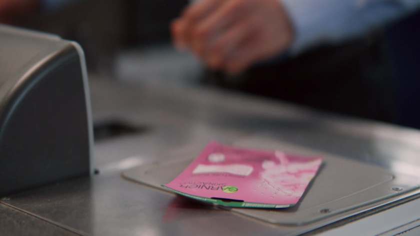 Close-up of a pink Garnier skincare product on the conveyor belt at checkout.
