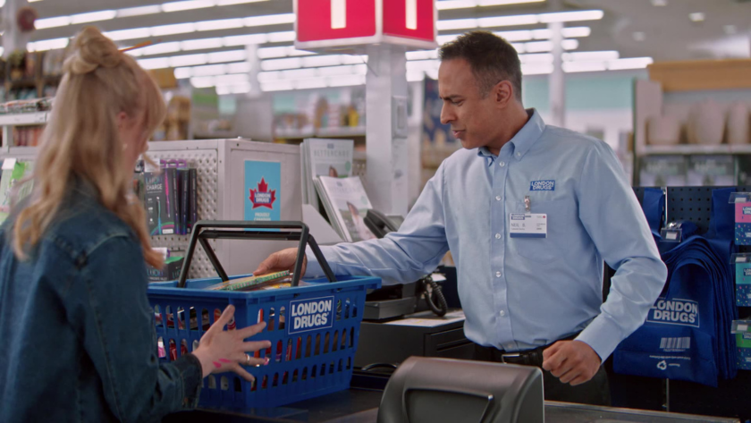 A London Drugs cashier scans items as a customer places a basket on the counter.