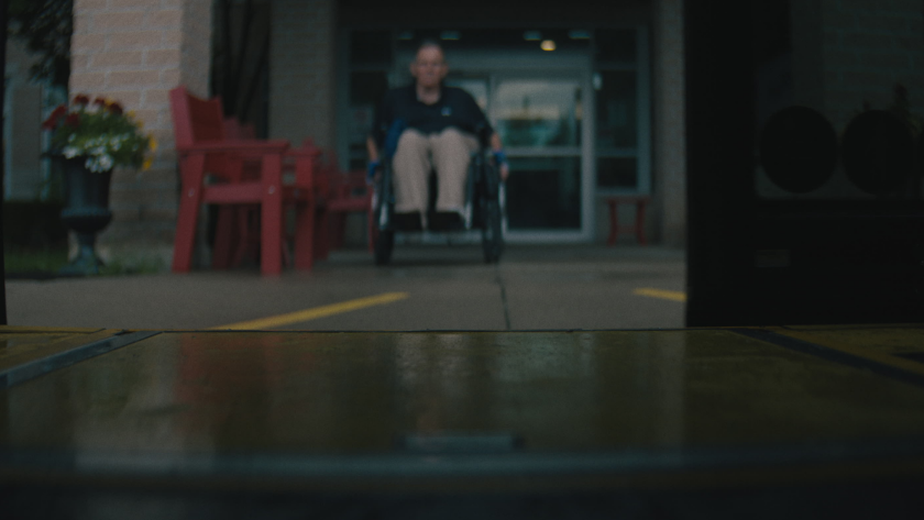 View from the bus ramp as a person in a wheelchair approaches the entrance.