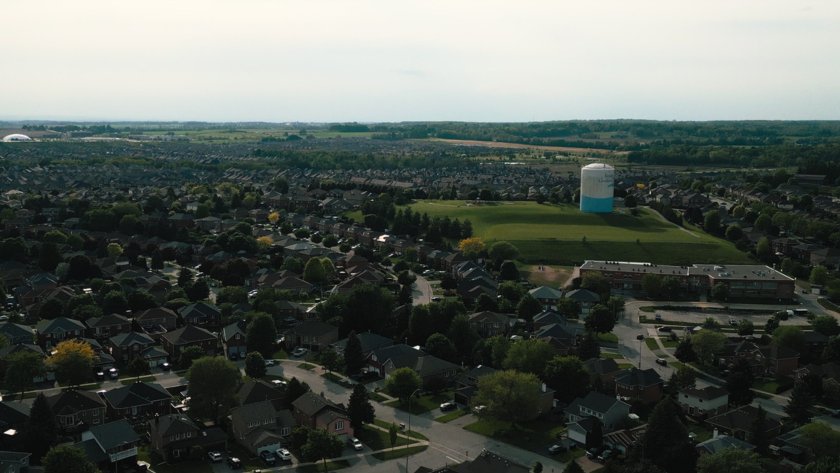 Aerial view of a suburban neighborhood with a large water tower in the distance.