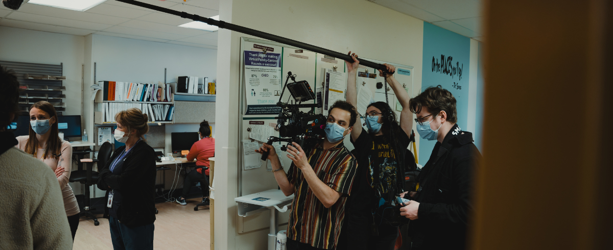 The production team taking a scene, holding their cameras and equipment.