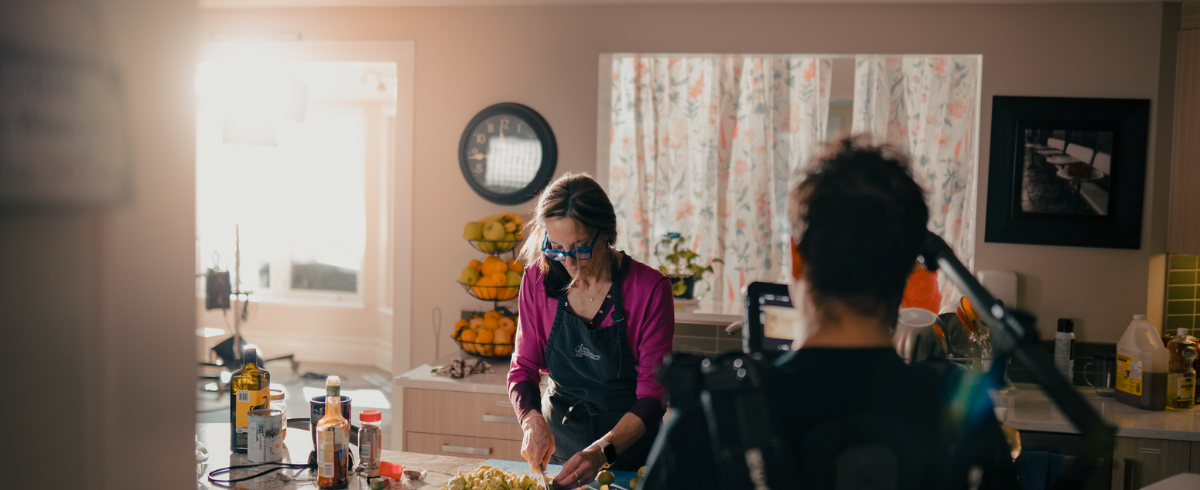 The scene where a lady is preparing food and cutting the ingredients in the kitchen.