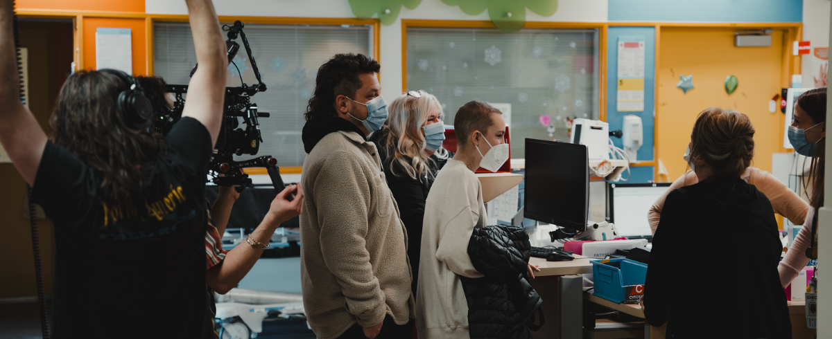 A scene inside the hospital with many people wearing facemasks.