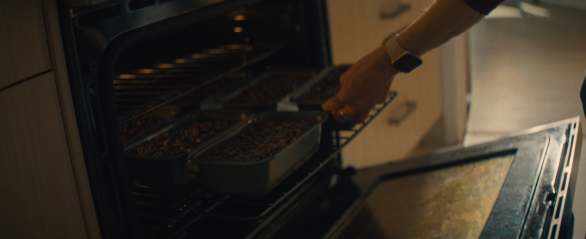 A lady is preparing food and cooking in the oven.