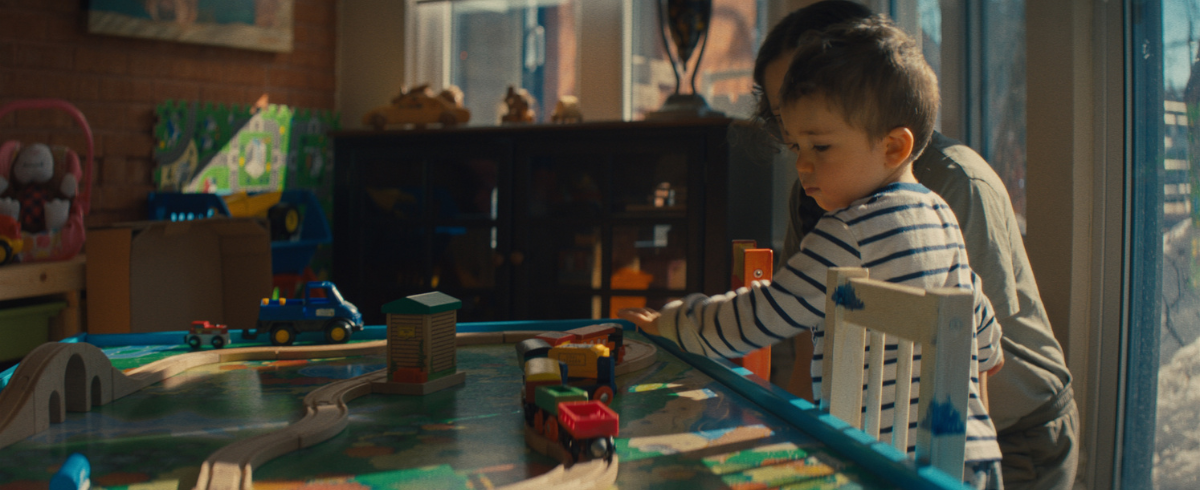 A kid playing with toys with their guardian.