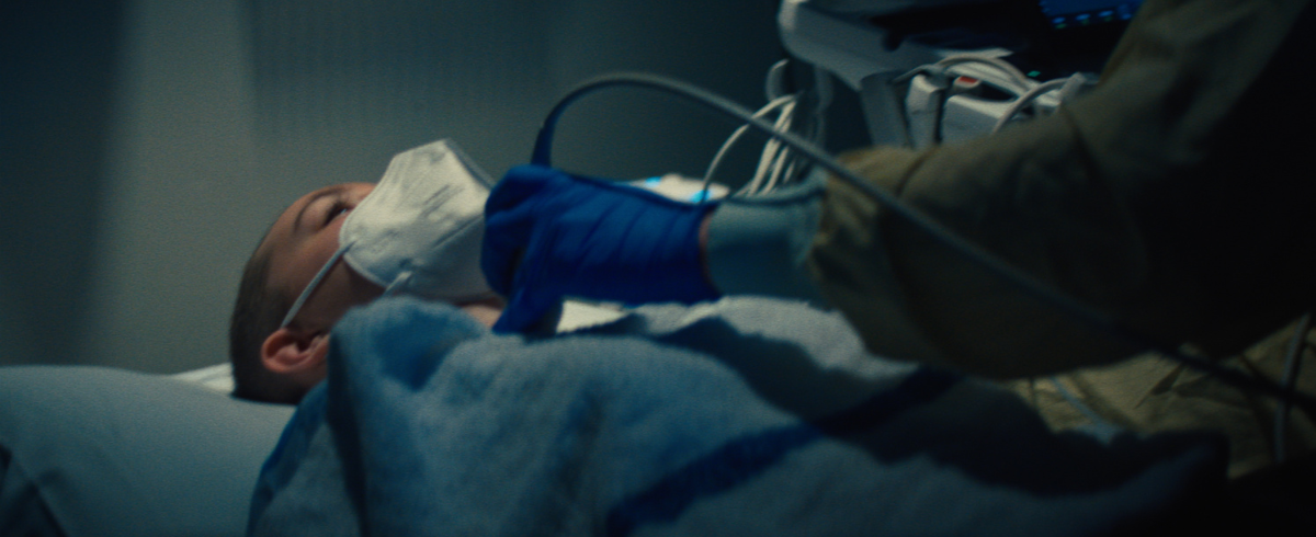 A leukemia patient lying in bed with medical equipment attached to her chest