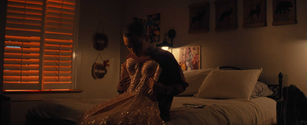 A leukemia patient fitting a prom dress in her room, looking really happy and excited.