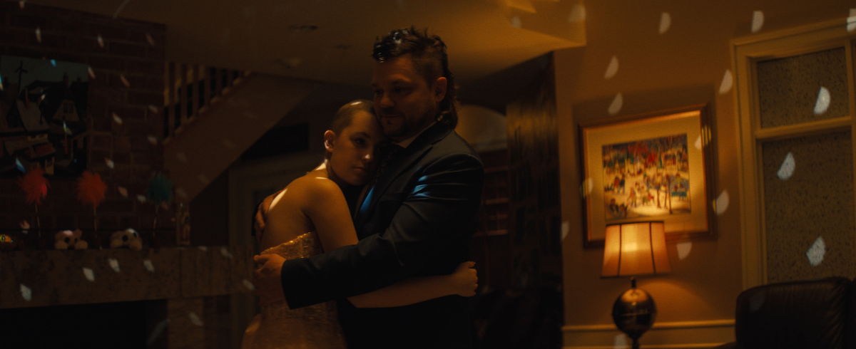 The leukemia patient is wearing her prom dress and dancing happily with her dad.