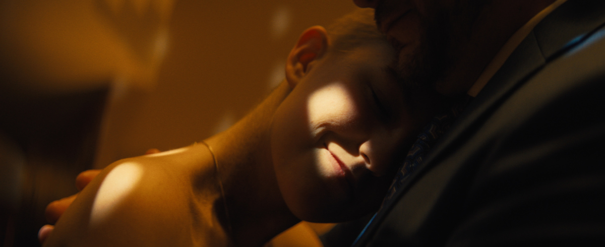 A leukemia patient resting his head on her dad's chest while dancing.