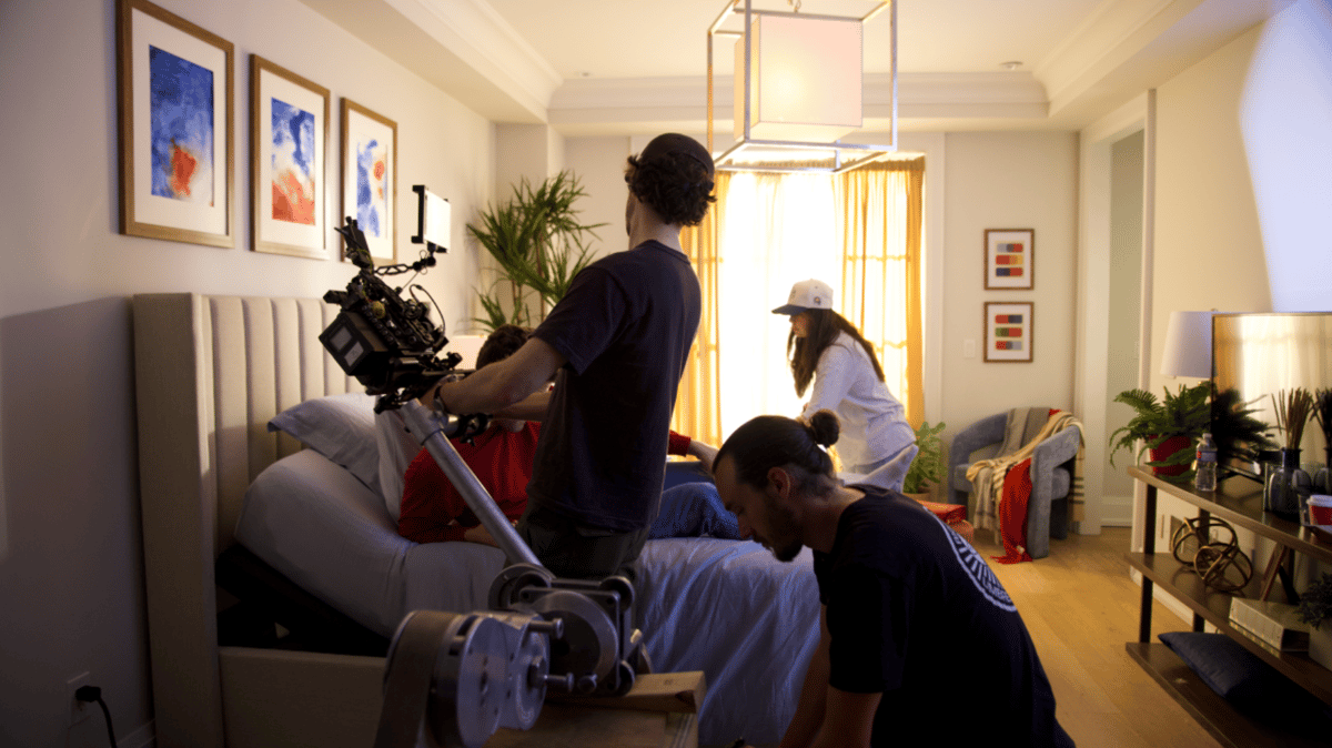 Videographer preparing to shoot the actor in bed.