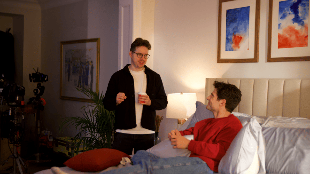 Director briefing the actor on set while he is in bed.