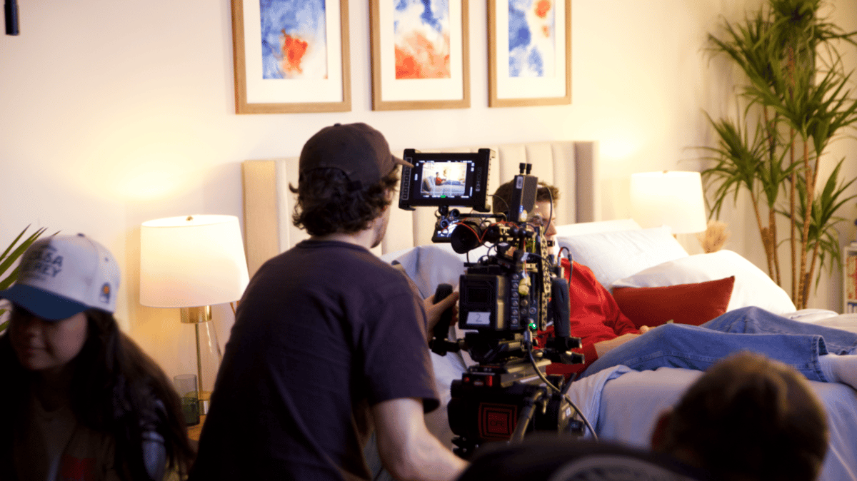 Actor sleeping on the bed while being filmed.