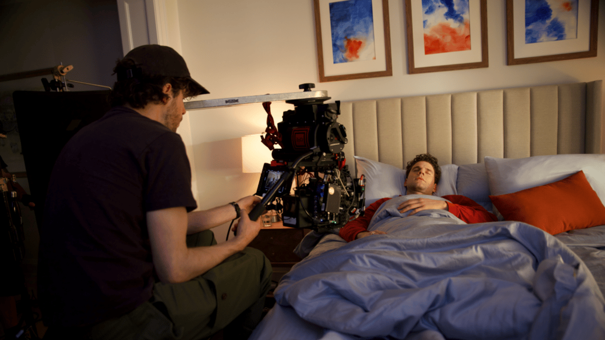 Actor sleeping on the bed while being filmed.