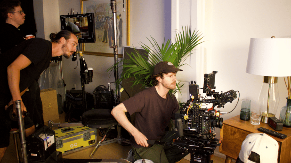 Videographer kneeling to set up for a shot.