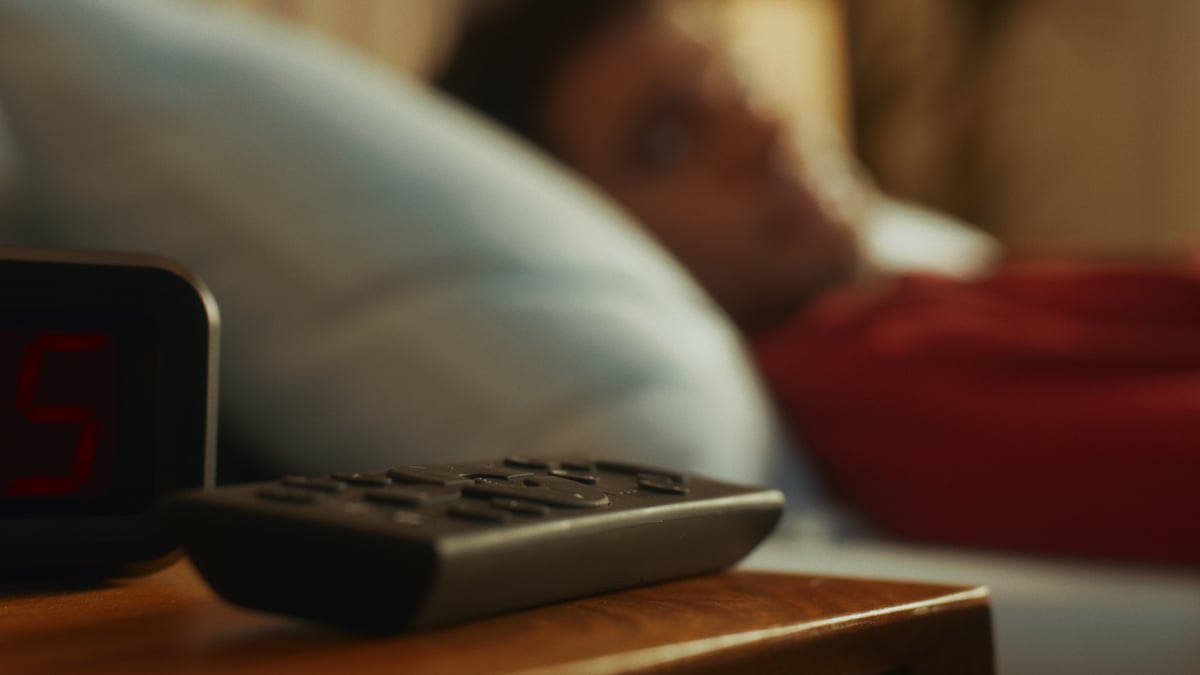 Close-up shot of the edge of a table with a remote.