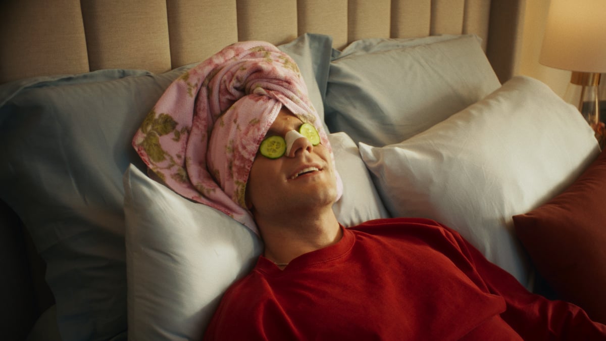 Man in complete relaxation with cucumbers on his eyes and a towel on his head.