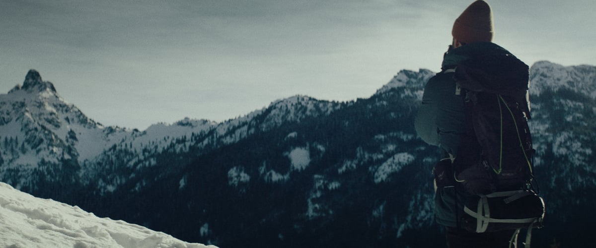 A man gazes at the breathtaking snow-covered mountain, captivated by its stunning beauty.