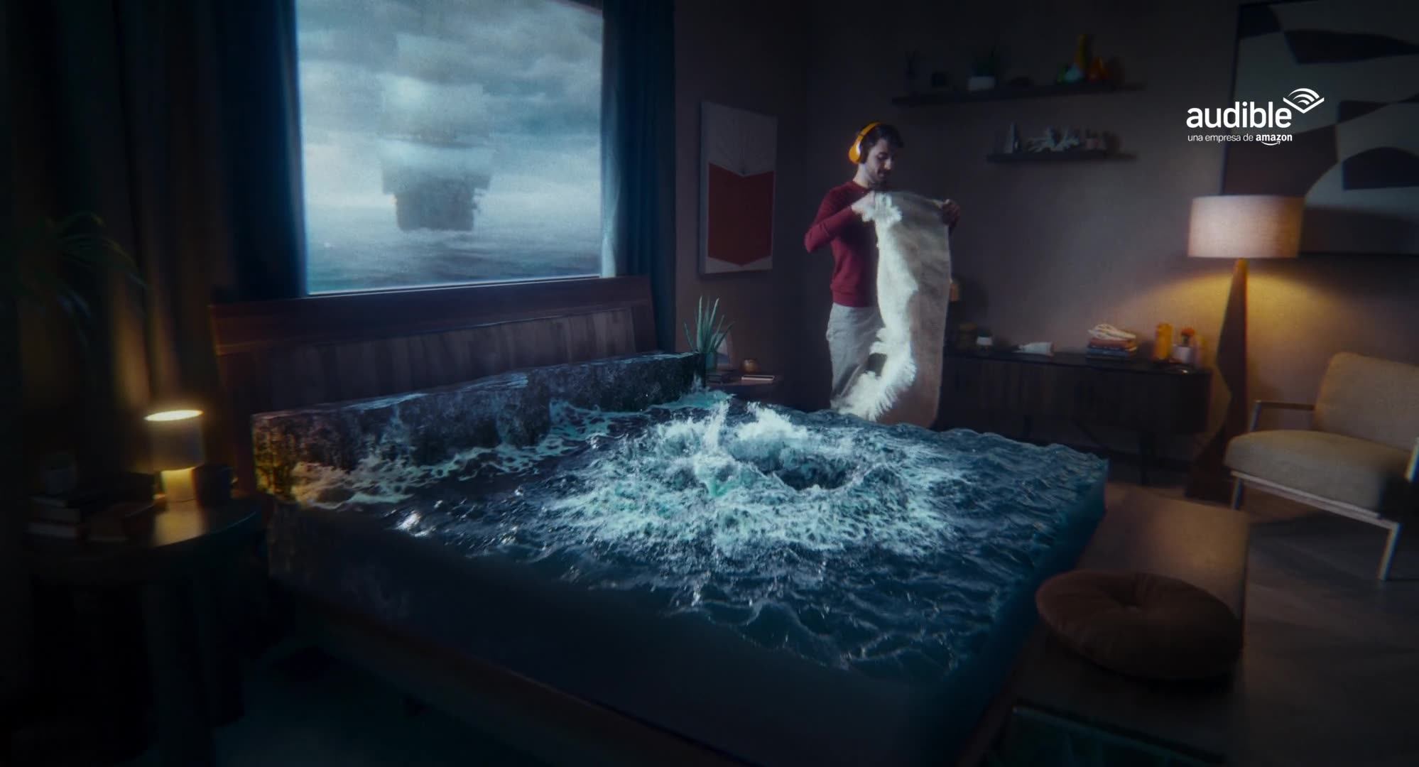 A man wearing headphones makes his bed while stormy ocean waves crash across the mattress in a surreal Audible ad.