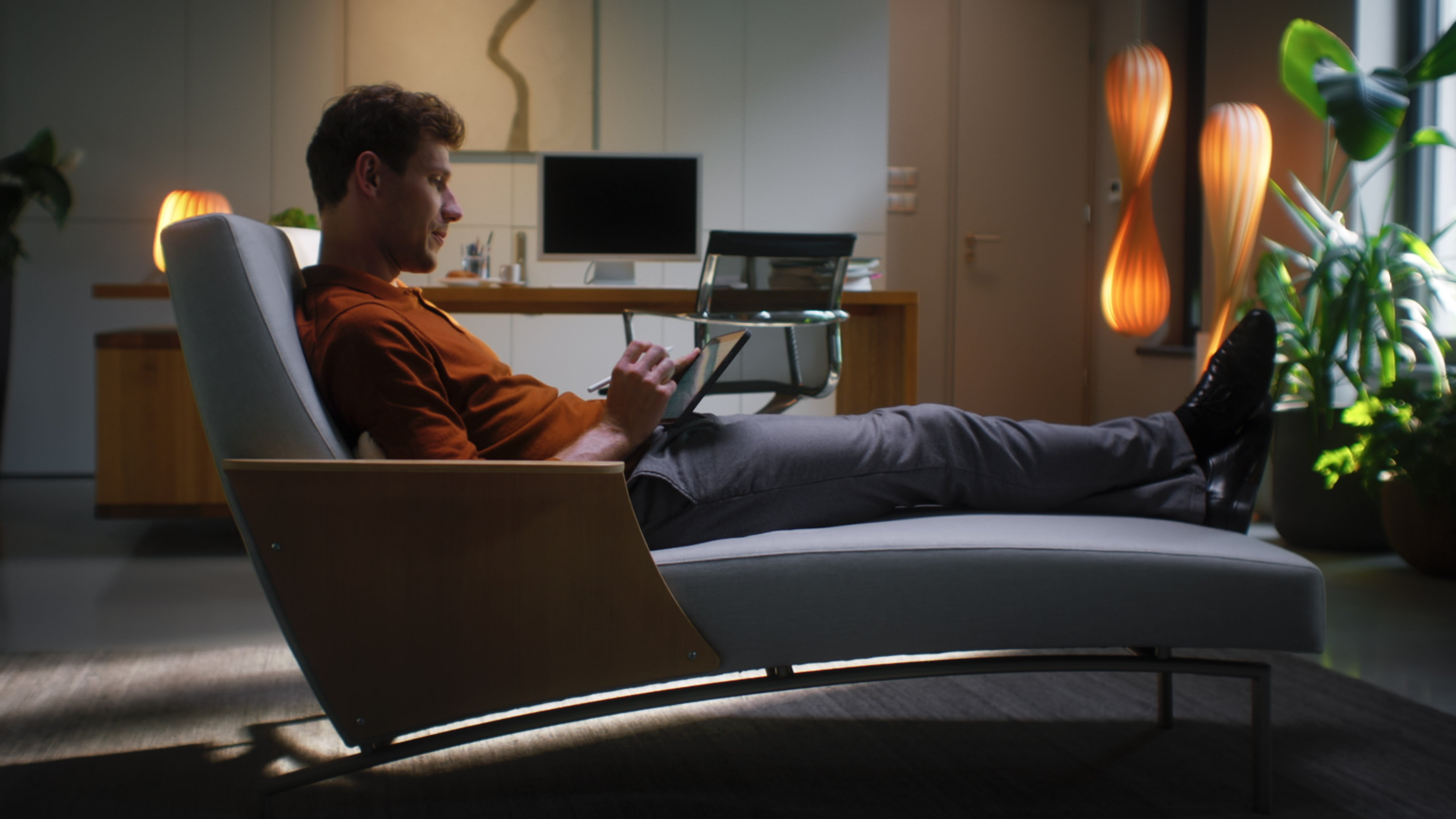 Man lying down, relaxed, using a tablet.