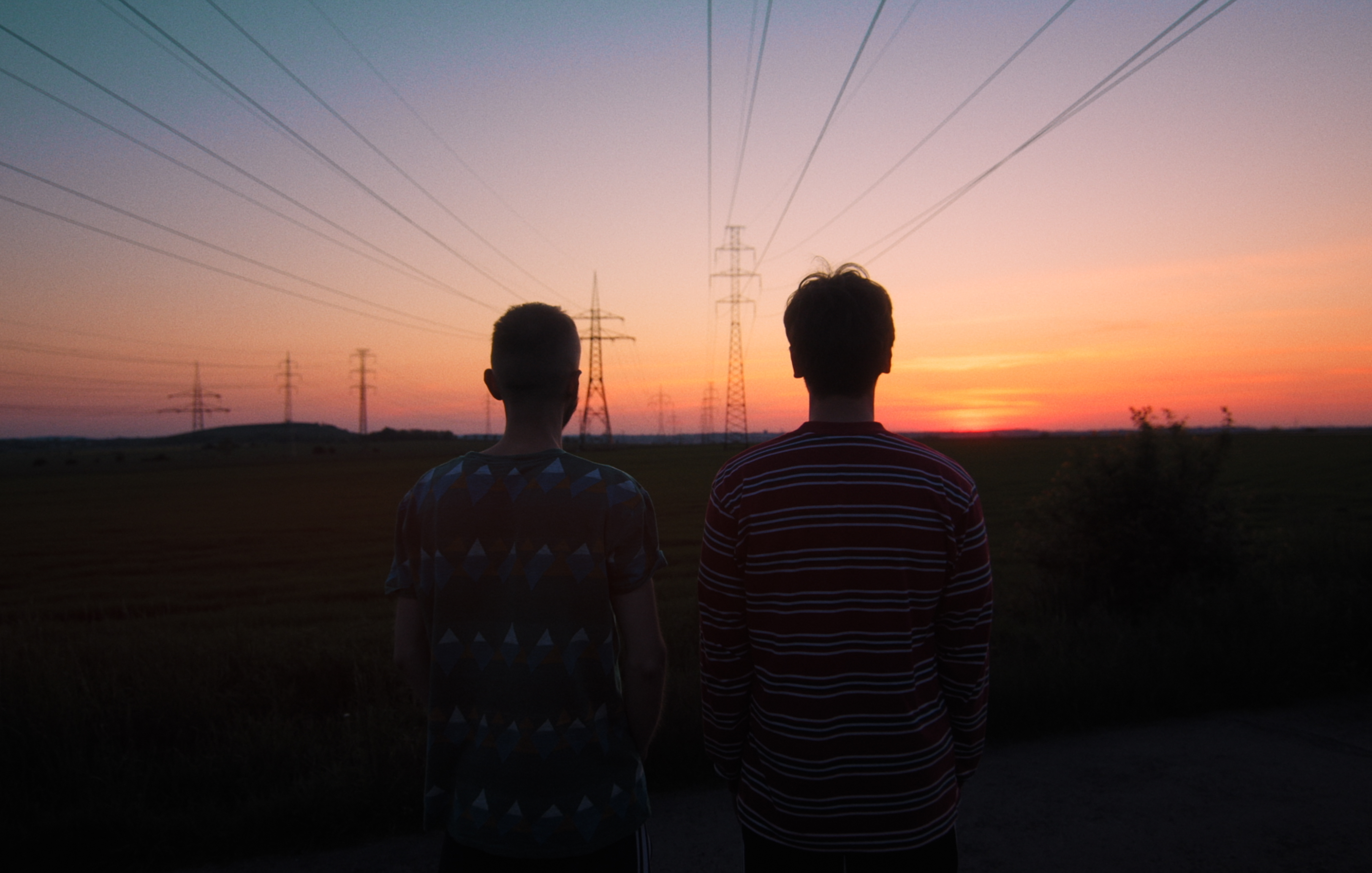 Two individuals beholding the beauty of the sunset.