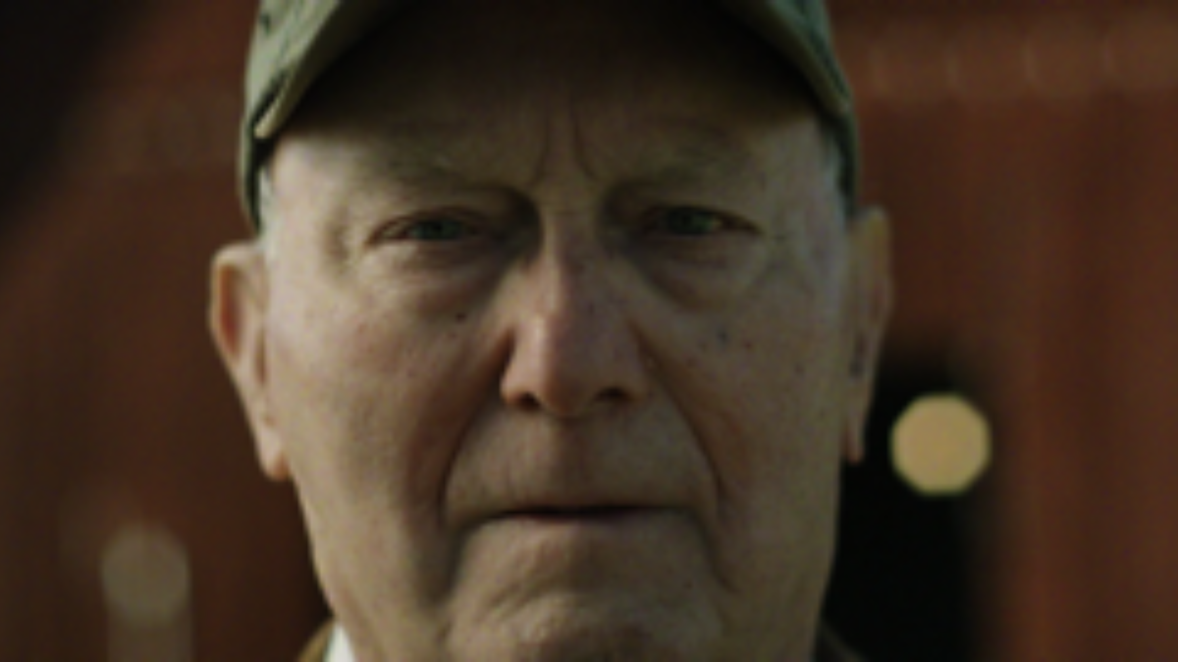 A close-up portrait of an elderly man outdoors, conveying emotion and authenticity through natural light.