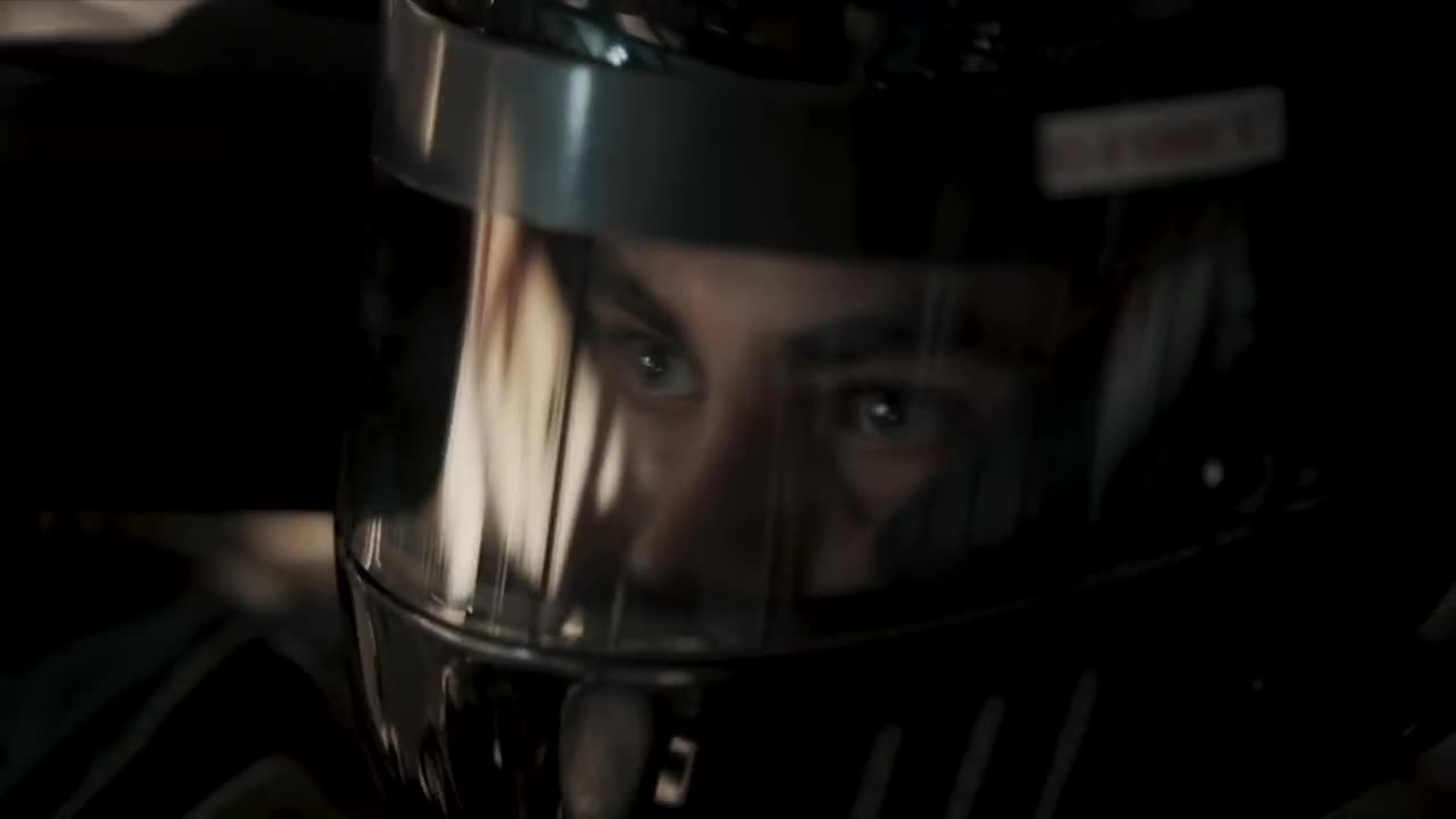 A close-up of a racer’s focused eyes behind a helmet visor, emphasizing determination and intensity.