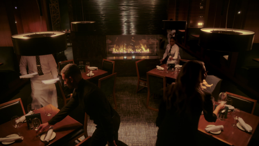 An atmospheric restaurant scene that blends practical lighting with rich warm tones to showcase luxury hospitality and fluid service choreography.
