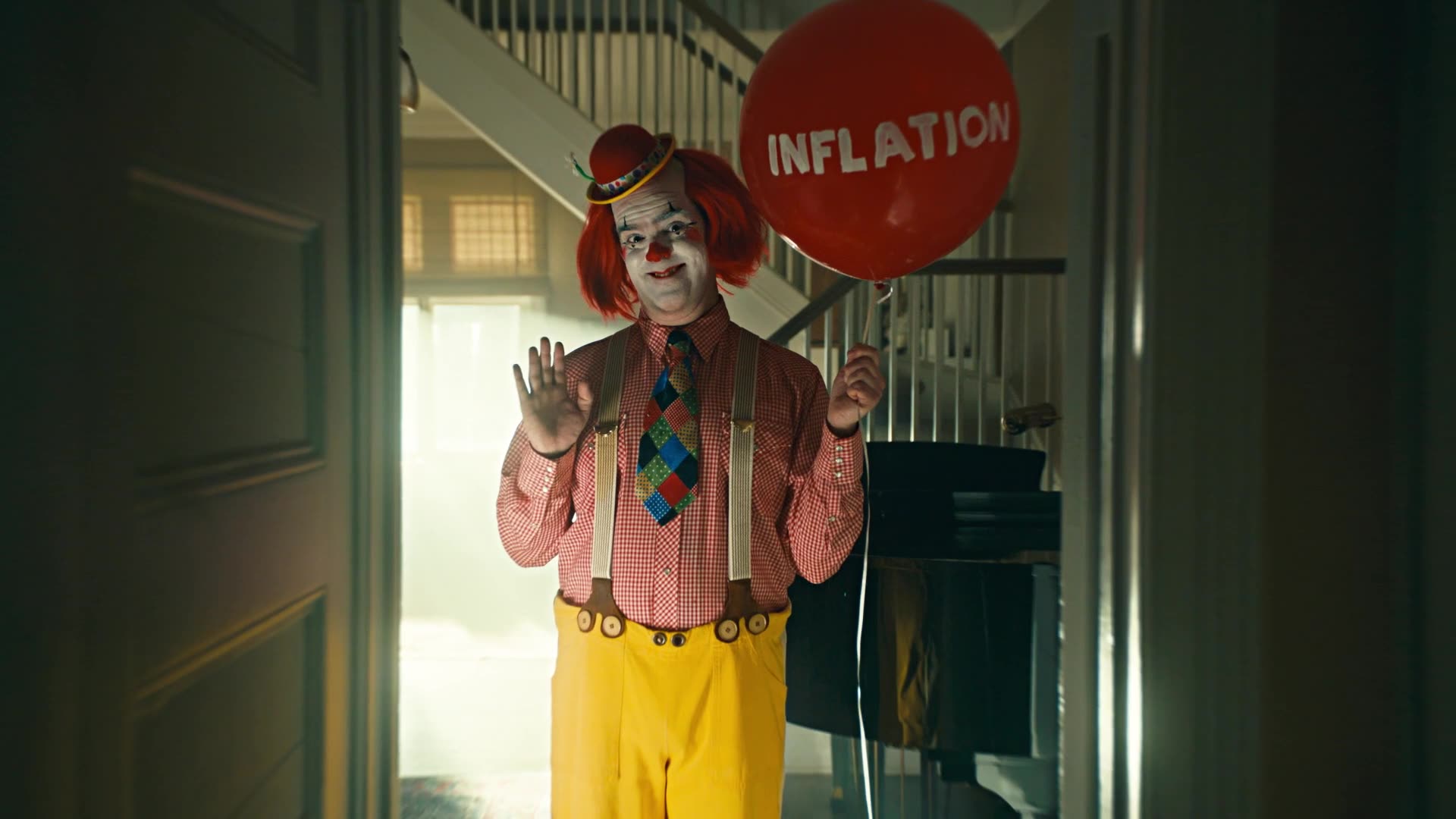 A clown holding a red balloon labelled Inflation stands in a doorway in a dark, cinematic scene.