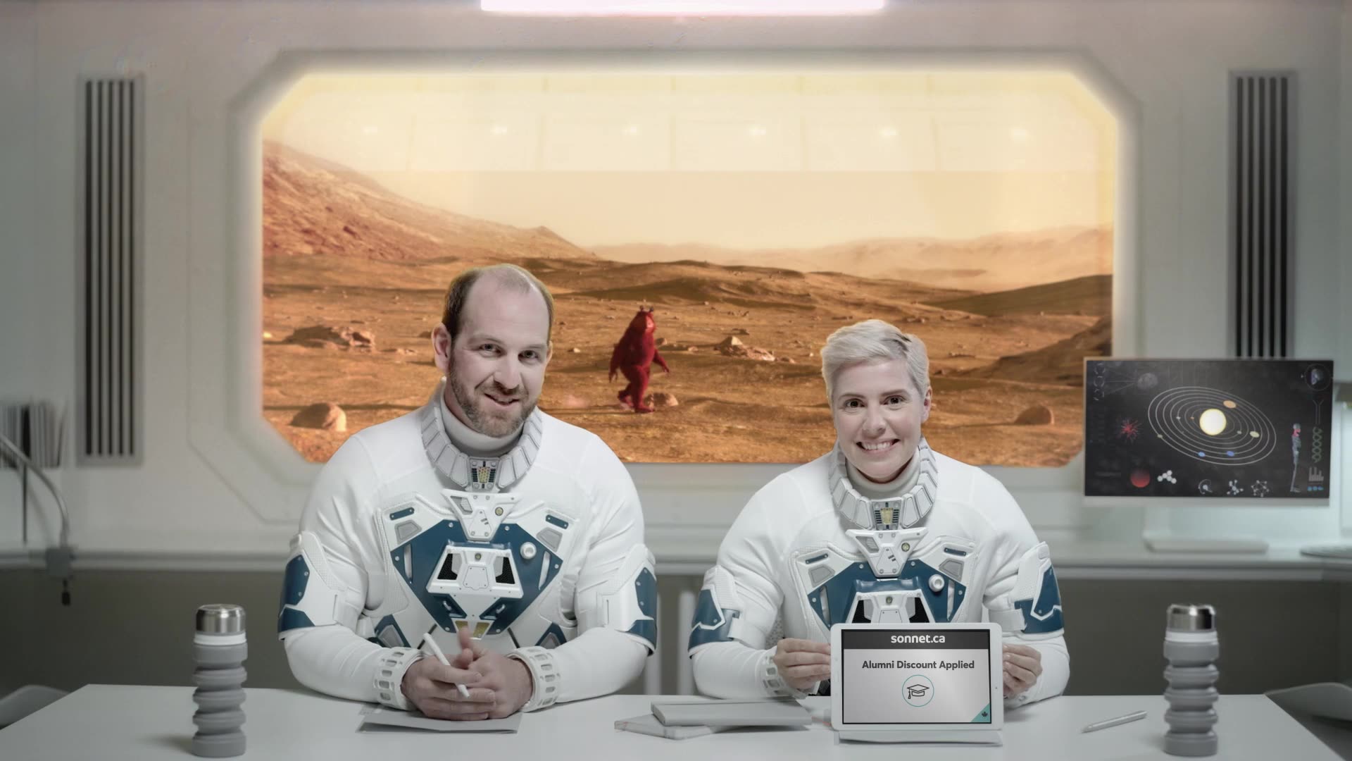 Two commentators in retro jerseys host a desk segment in front of a Mars landscape backdrop.